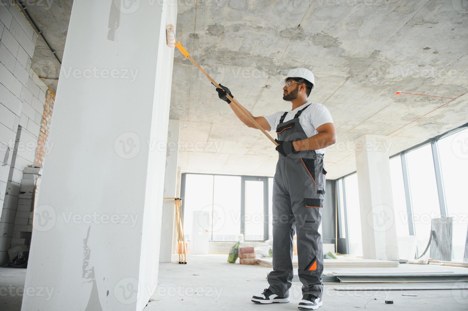 painter-doing-painting-work-on-wall-with-roller-concept-of-hard-working-home-renovation-photo