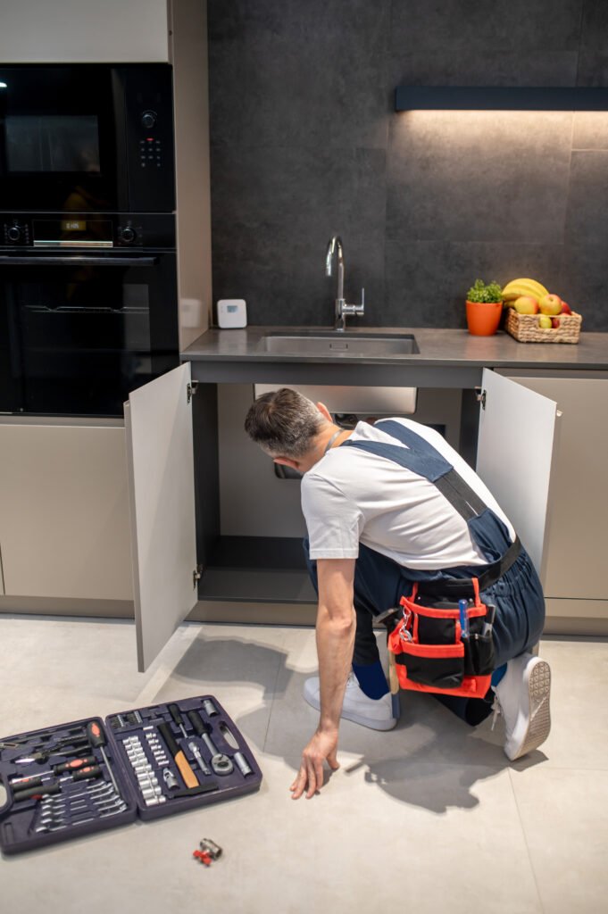 Custom Kitchen Renovation 5 back view man crouching near kitchen sink