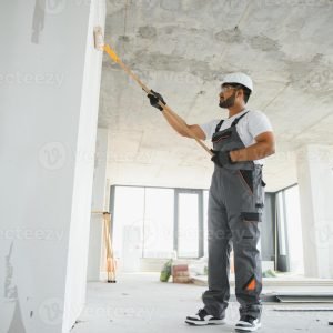 Professional painter applying fresh paint during home renovation